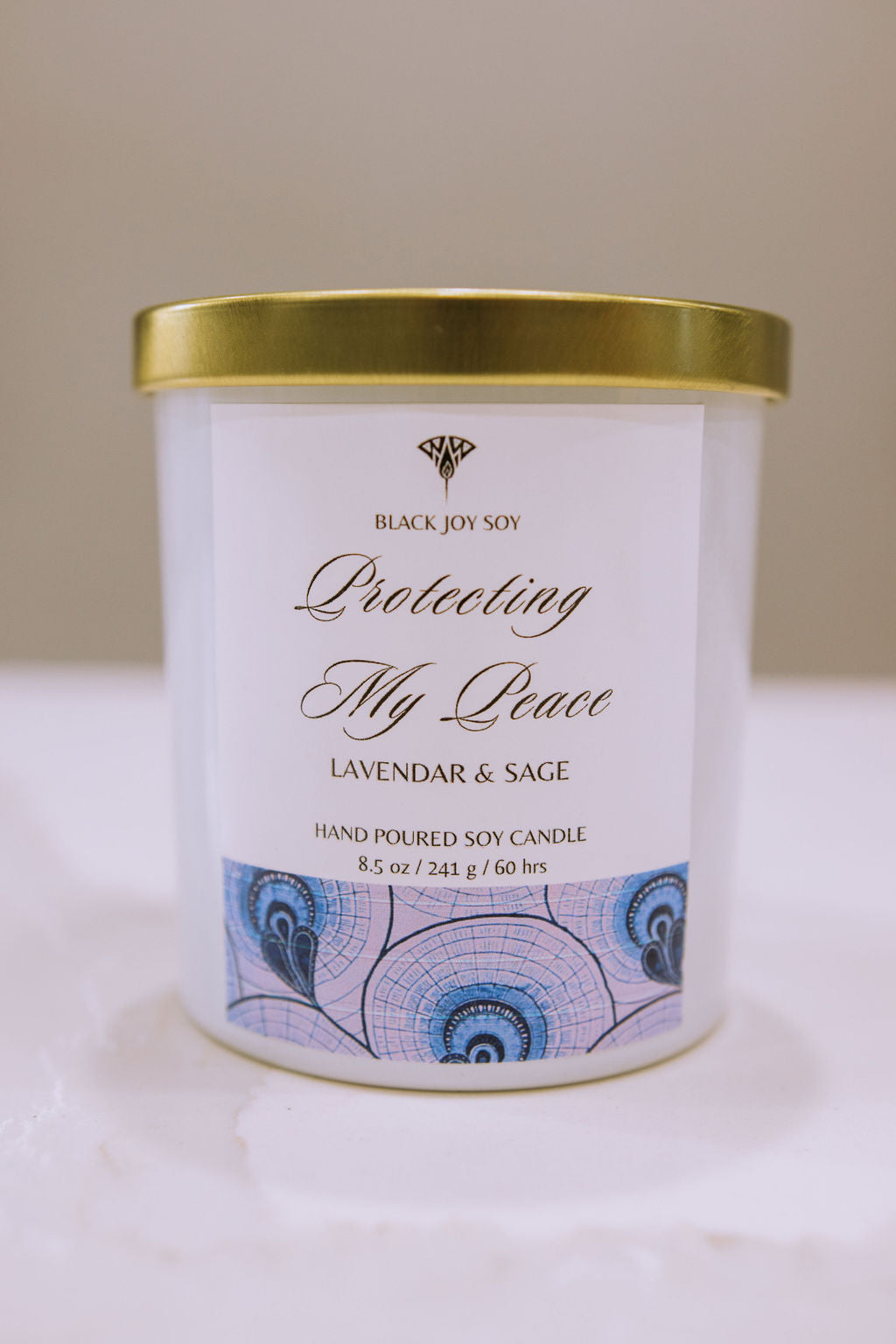 This is a 8.5 ounce Lavender Sage & Vanilla soy scented candle in a white jar white a purple label.