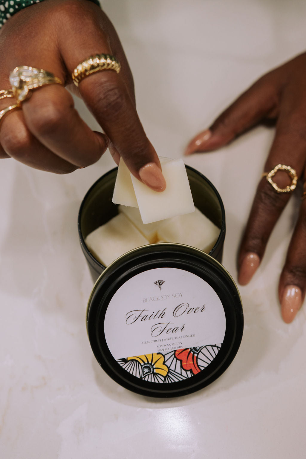 black metal tin with 16 Grapefruit, white tea & ginger scented soy wax melts inside. The tin has a label with the words "Faith Over Fear" written on it.